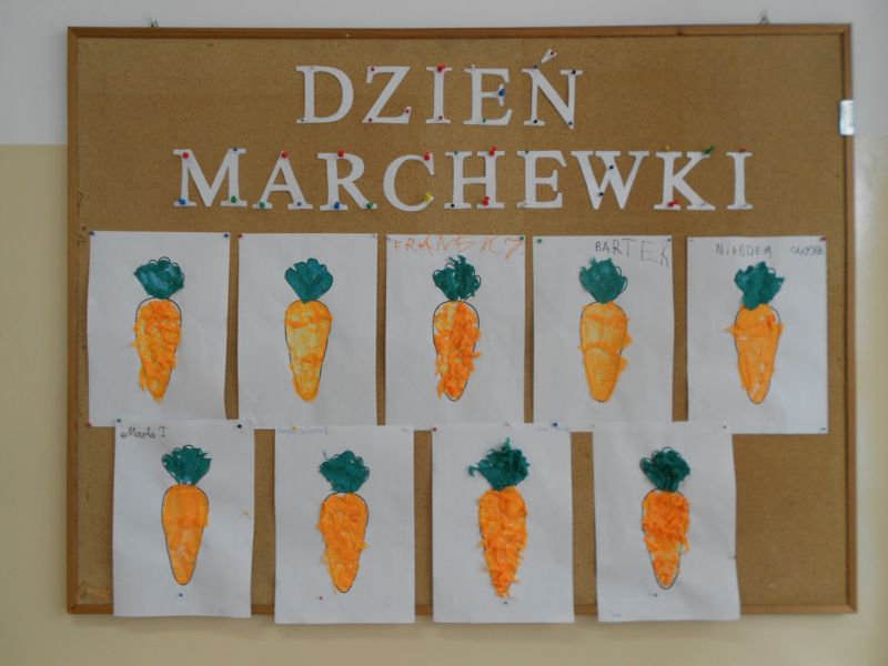 Prace uczniów z marchewką w tle
